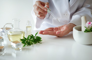 Fototapeta na wymiar the scientist,dermatologist testing the organic natural cosmetic product in the laboratory.research and development beauty skincare concept.blank package,bottle,container .cream,serum.hand