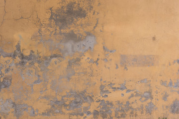 Old cracked yellow wall as background or wallpaper