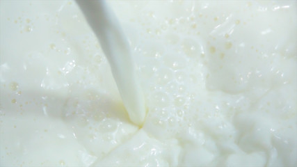 Pouring fresh milk into clean dishes in slow motion