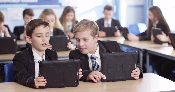 4k, High school children using digital tablets while sitting in class.