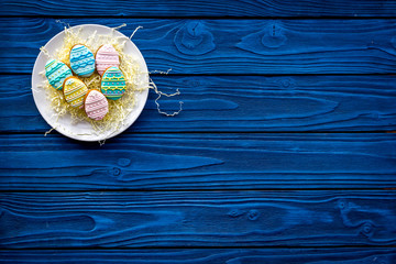 Obraz na płótnie Canvas Easter eggs cookies. Sweets, pastry for Easter table. Blue wooden background top view copy space