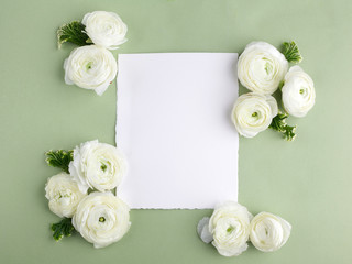 Fototapeta na wymiar Floral frame made of white flowers and leaves on green background. Floral background. Flat lay, top view.