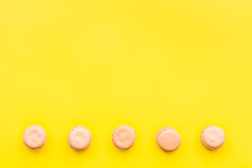 Macarons dessert. Pattern on yellow pastel background top view copy space