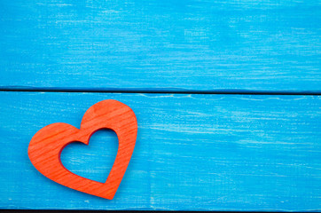 red wooden heart on a blue background