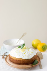 Lemon cake with whipped cream on a light background.