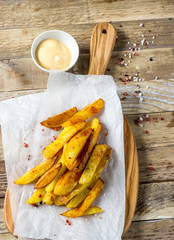 Traditional French fries on wooden cutting board