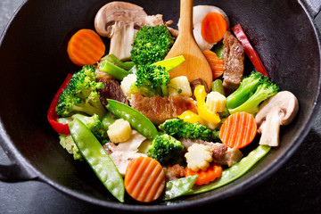 stir fried vegetables with meat in a wok