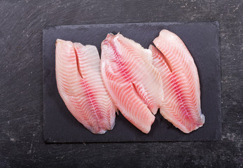 fresh fish fillet on dark board