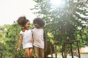 Fototapeta premium Children Friendship Togetherness Smiling Happiness Concept.Cute african american little boy and girl hug each other in summer sunny day