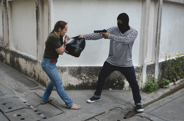 Mask robber holding a gun want to steal woman bags,Dangerous criminal in the city