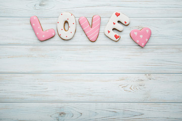 Inscription Love by homemade cookies on wooden table