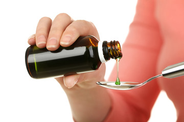 Female hands pouring medical syrup in spoon