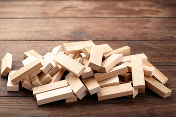 Heap of wooden blocks tower game on brown table