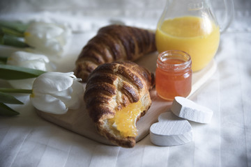 Croissants, orange fresh and tulips.  Breakfast in bed.  