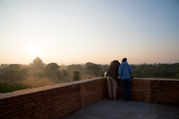 A couple love tourist standing on pagoda to see beautiful landscape view of sunrise and romantic...