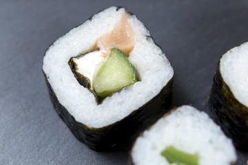 Sushi with chopsticks on black background