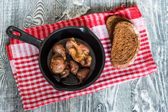 Top view roasted chicken giblets in pan and bread