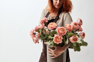 Pretty woman holding a vase with fresh pink roses