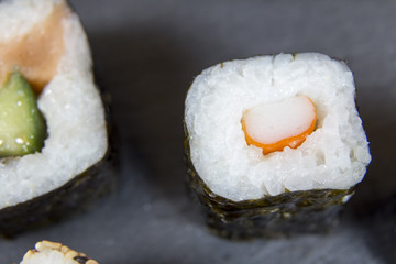 Sushi with chopsticks on black background