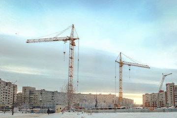 Fototapeta na wymiar two cranes at construction site