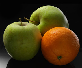 apples and apallsin on a black background rolls on a black background isolates 