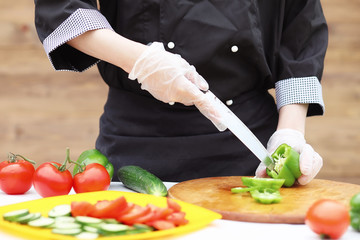 The cook cuts fresh farm vegetables
