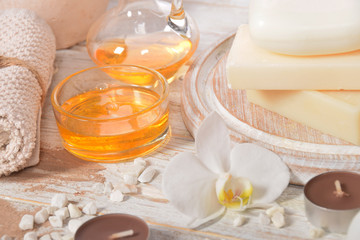 gray natural soap with honey and body oil and a cosmetic face mask