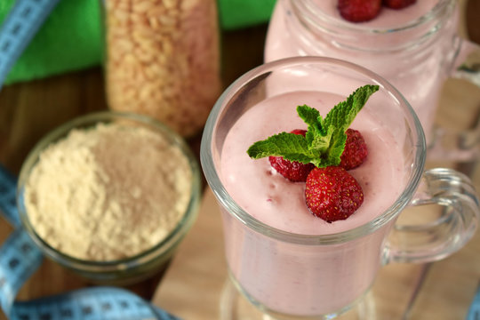 Protein cocktail with strawberries and mint in an Irish mug on wooden background