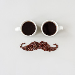 Mustache made of coffee beans with glasses made of cups of coffee