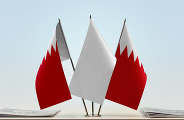 Two flags of Bahrain with a white flag in the middle