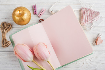 Pink notebook, tulips and lit candle