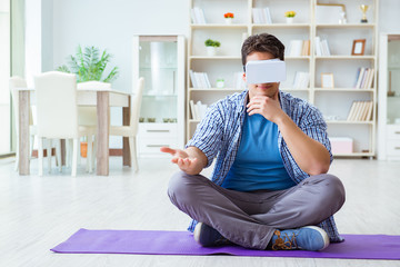 Man wearing virtual reality VR glasses meditating on floor at ho