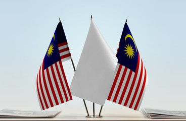 Two flags of Malaysia with a white flag in the middle
