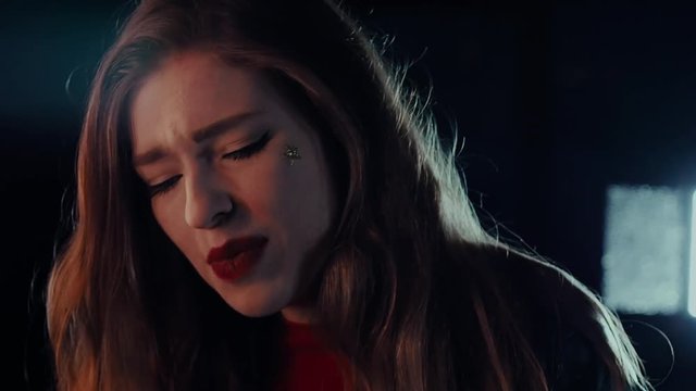 Attractive girl singing near the mirror. Portrait woman closeup. Steadicam