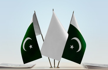 Two flags of Pakistan with a white flag in the middle