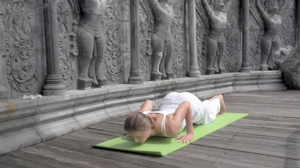 Young woman practicing yoga on the sunset beach