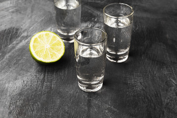 Cold vodka in shot glasses on a black background