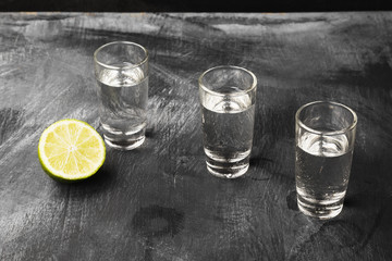 Cold vodka in shot glasses on a black background