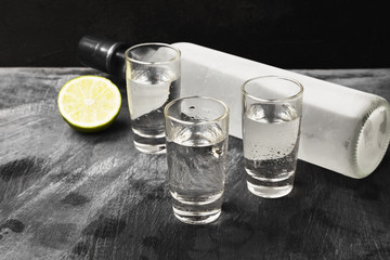 Cold vodka in shot glasses on a black background. Copy space. Food background