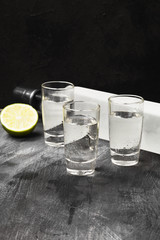 Cold vodka in shot glasses on a black background