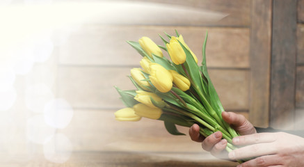  bouquet of yellow tulips in a vase on the floor