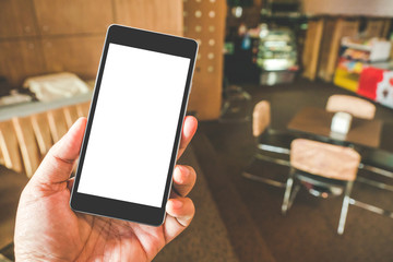 Hand holding black mobile smart phone with blank black screen in coffee shop cafe. technology and lifestyle concept.
