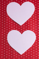 white hearts carved from paper on a red background. Valentine's Day greeting card