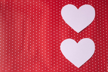 white hearts carved from paper on a red background. Valentine's Day greeting card