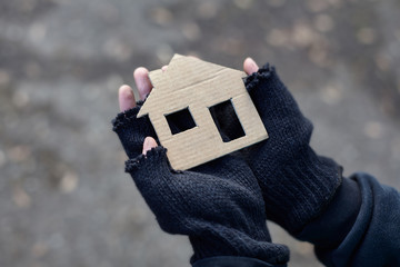 homeless boy holding a cardboard house