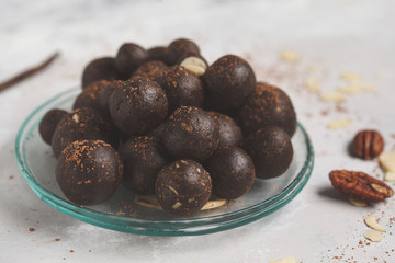 Vanilla-chocolate raw vegan sweet balls with nuts, dates and cocoa. Healthy vegan food concept. Gray background