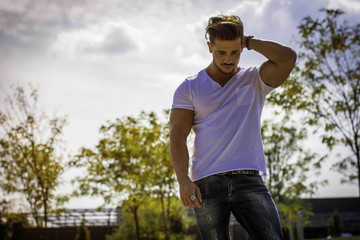 Attractive muscular man in city park in a nice summer day