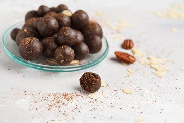 Vanilla-chocolate raw vegan sweet balls with nuts, dates and cocoa. Healthy vegan food concept. Gray background