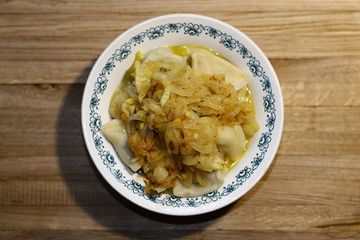 Cooked dumplings in a plate on a wooden table