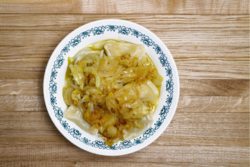Cooked dumplings in a plate on a wooden table